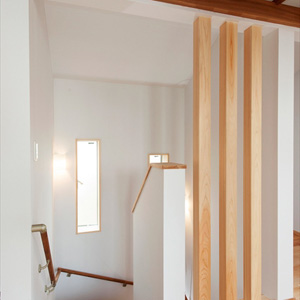 階段２階廊下部分を檜柱材で格子にし1、2階の空間をつなぐ　　縦長窓で光をとりこむ