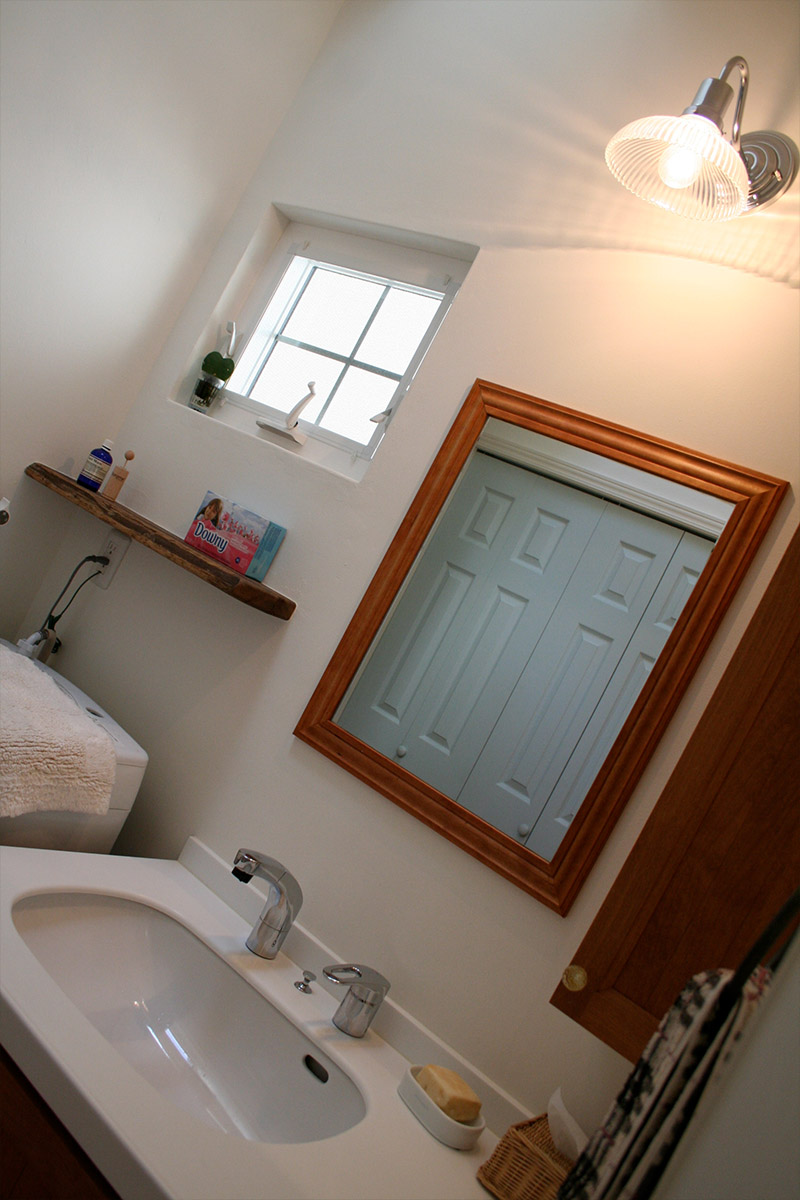 すっきりとした印象の洗面室。対面にあるペールブルーのドアが優しい印象です