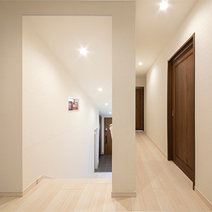 廊下：敷地の高低差を活かし、中二階のようなステップフロア設計。各部屋への日当たりやプライベート空間の自然な分離にもなる配置です。