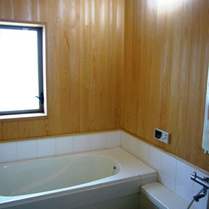 桧の板を壁・天井に貼った浴室。腰から下はハーフユニットバスを使用しています。とても快適なバスライフを楽しめます。