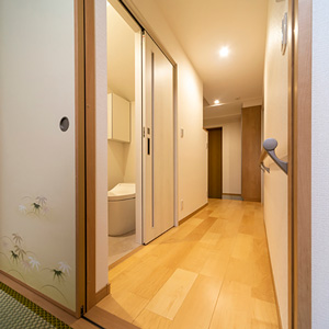 １階の玄関から和室に続く廊下。トイレのドアは引き戸にして、省スペースで開閉できます。
