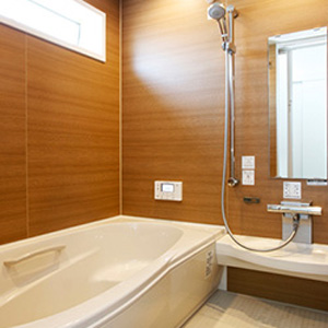 浴槽上の窓から差し込む優しい光と、木目を基調とした壁が、温かみのある空間を生み出します。