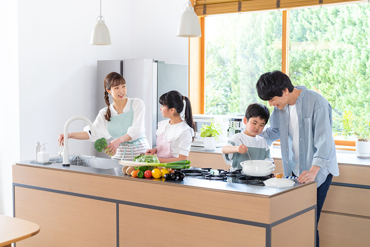 キッチンで料理する4人家族